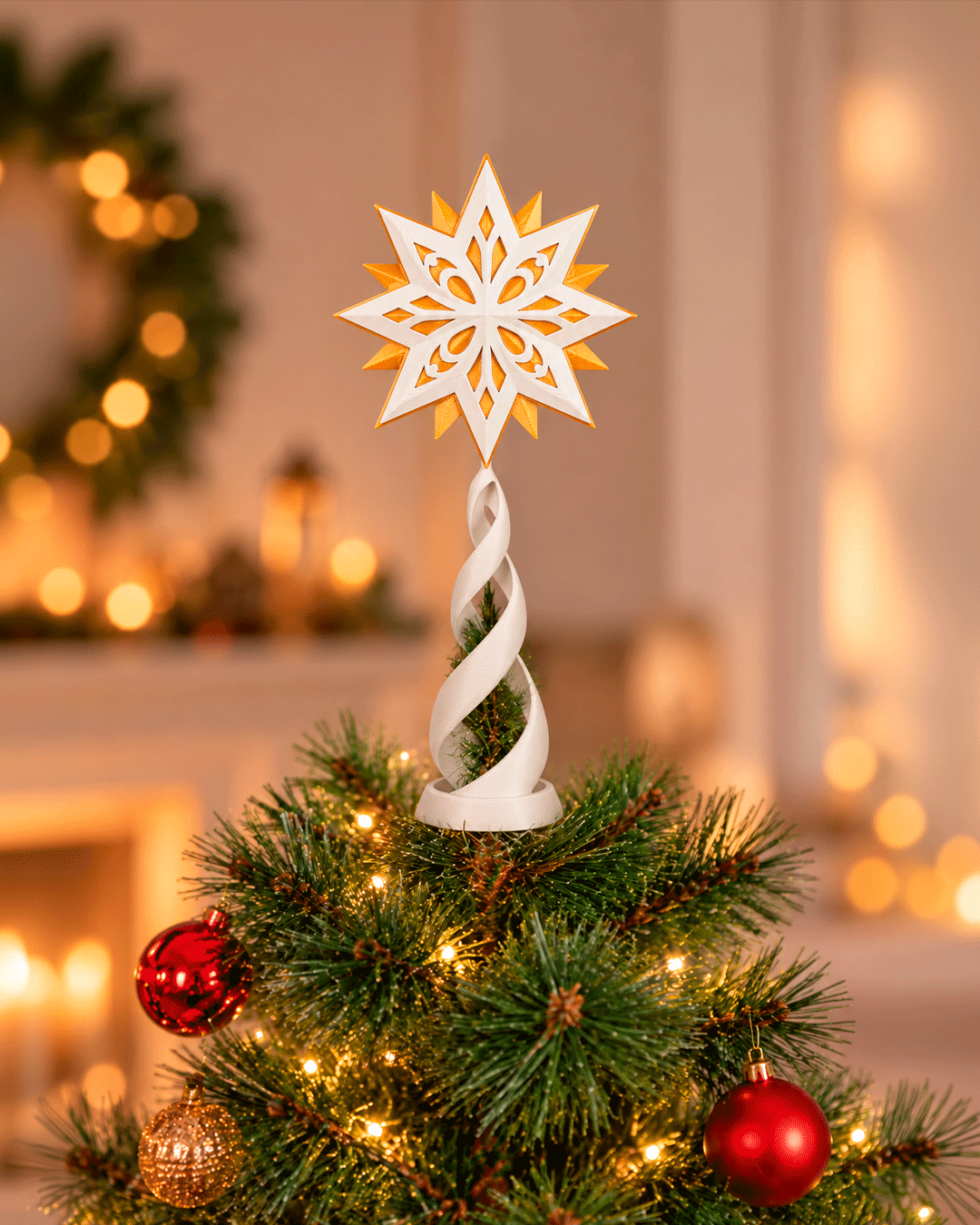 White and gold geometric star topper on a white spiral stand, on top of a lit Christmas tree