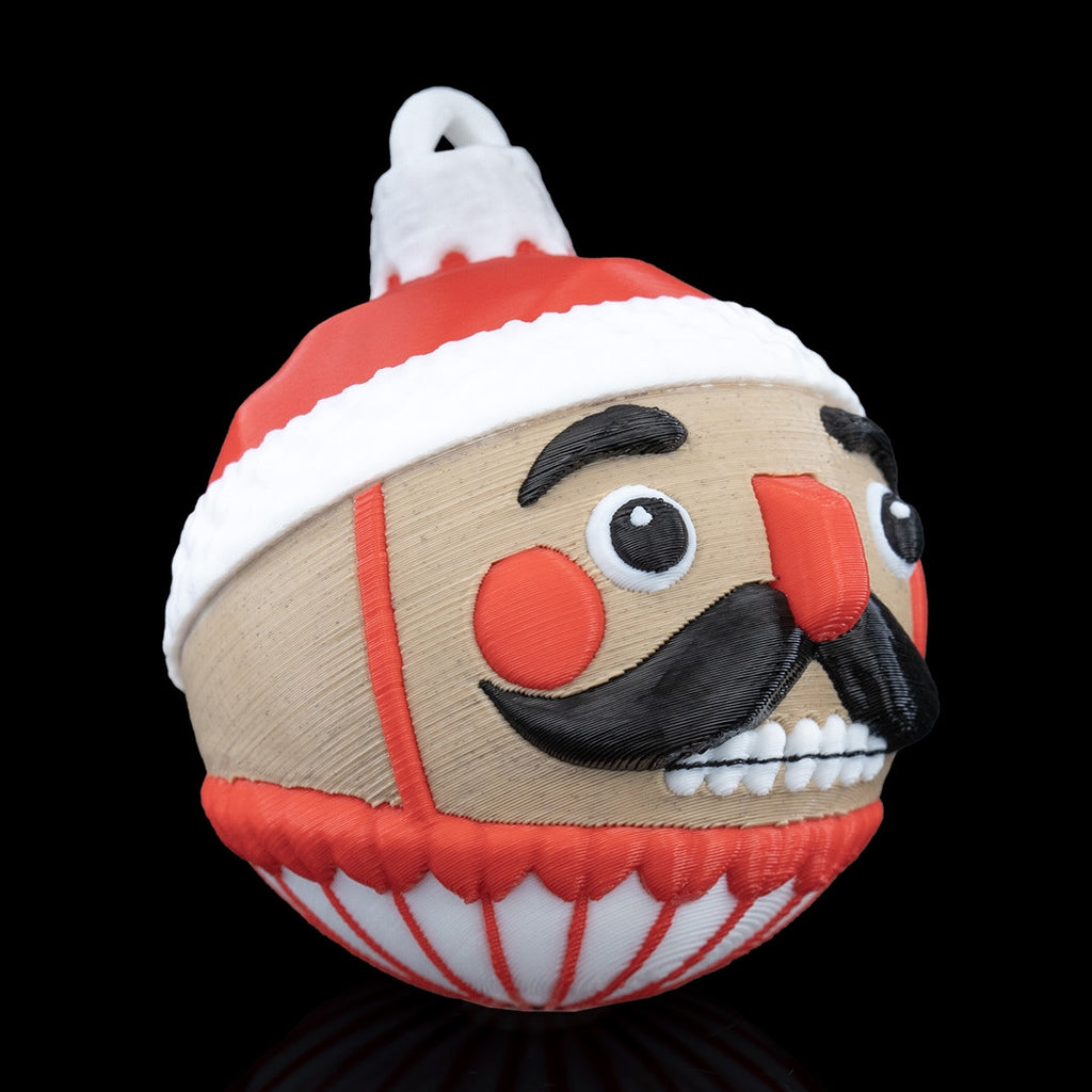 Nutcracker Christmas ornament turned to the right, showing the mustache, red nose and printed hanging loop, on a black background