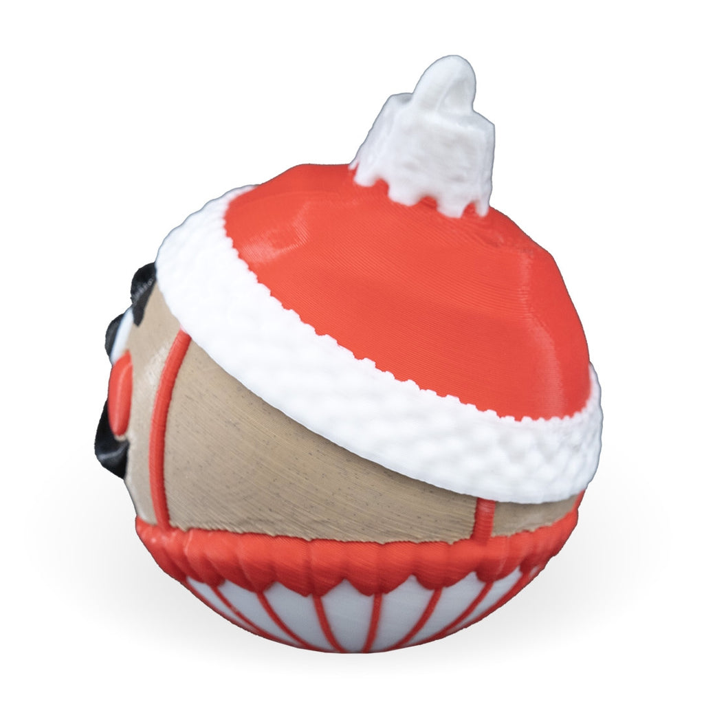 Back-side view of the Nutcracker Christmas ornament with red hat, white trim and printed loop, on a white background