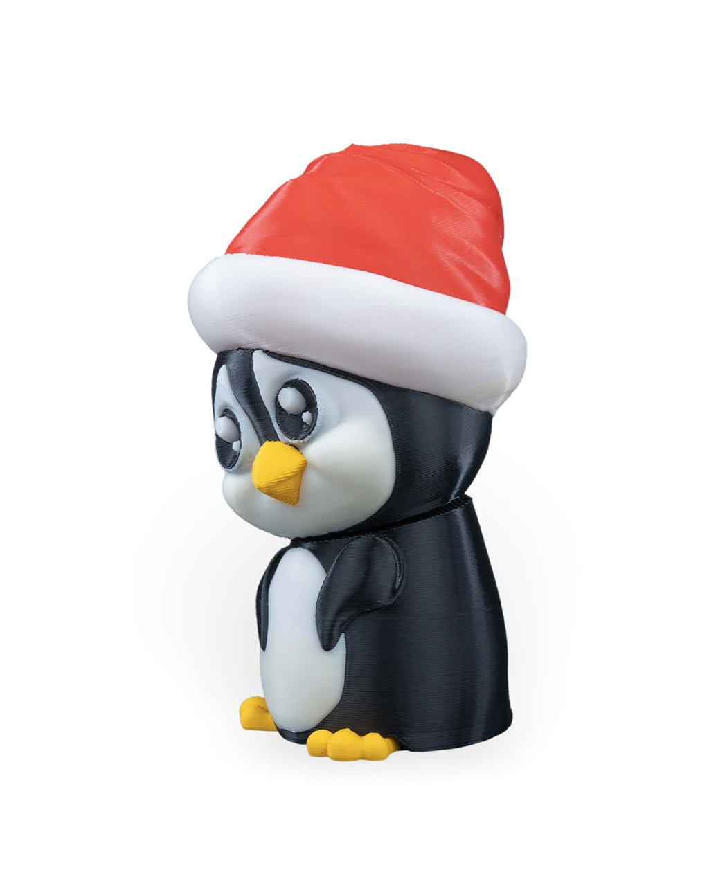 Penguin in Santa Hat Christmas ornament angled to the left, showing the big eyes and wing, on a white background