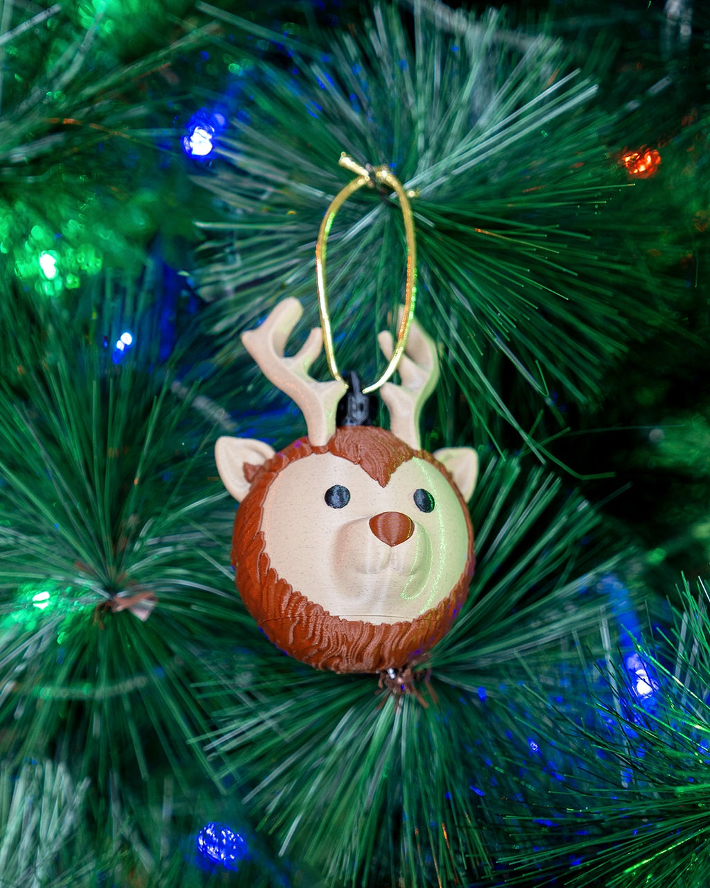 Reindeer Head Christmas ornament hanging on a lit Christmas tree