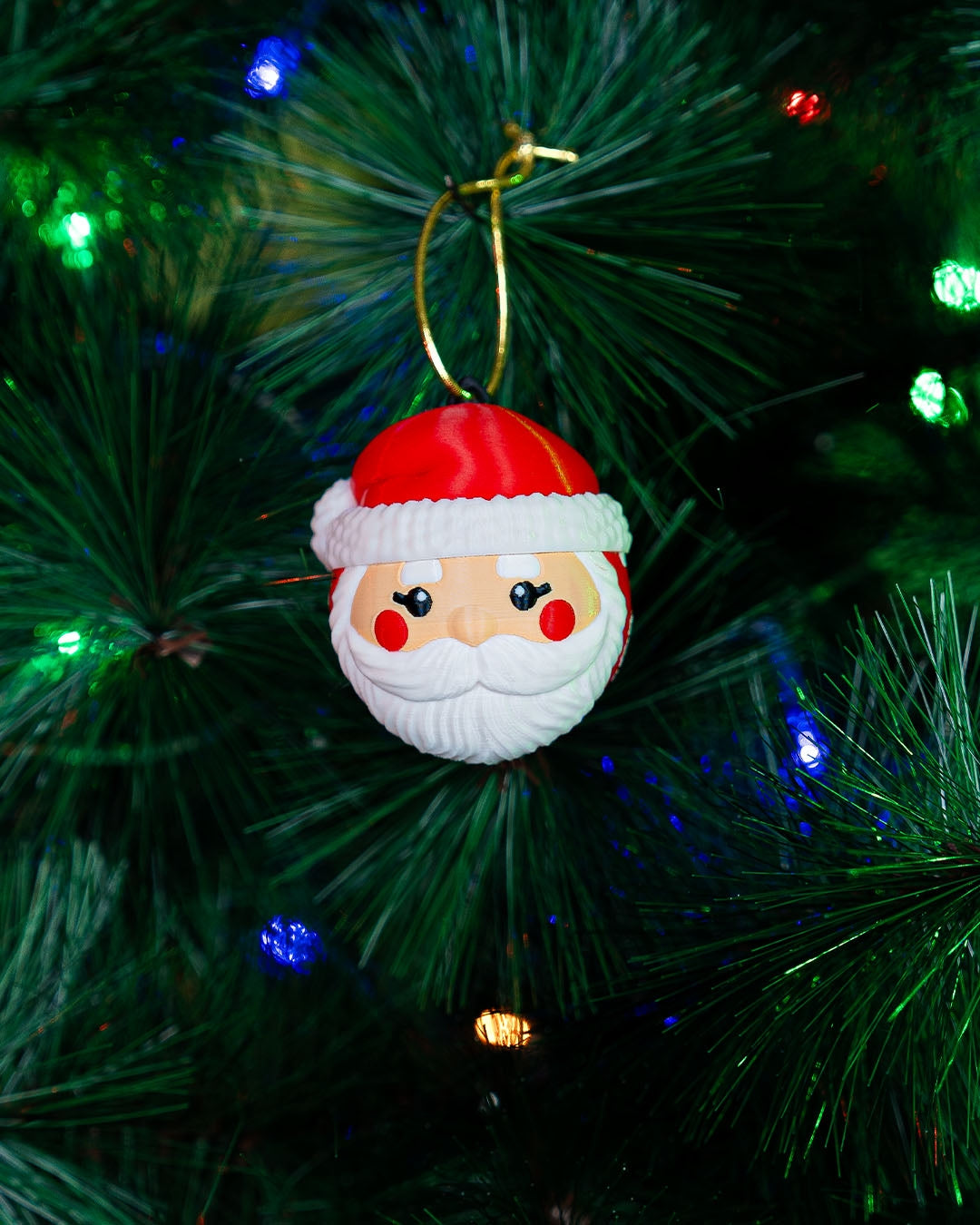 Santa Face Christmas ornament hanging on a lit Christmas tree