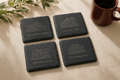 Set of four laser-engraved slate coasters showing sample home addresses — placeholder image
