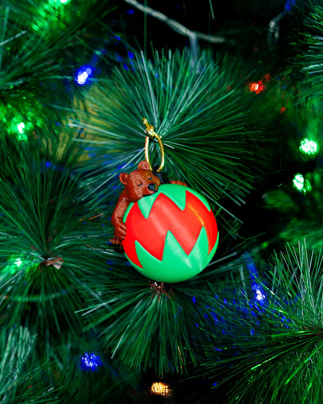 Sleeping Bear Christmas ornament hanging on a lit Christmas tree