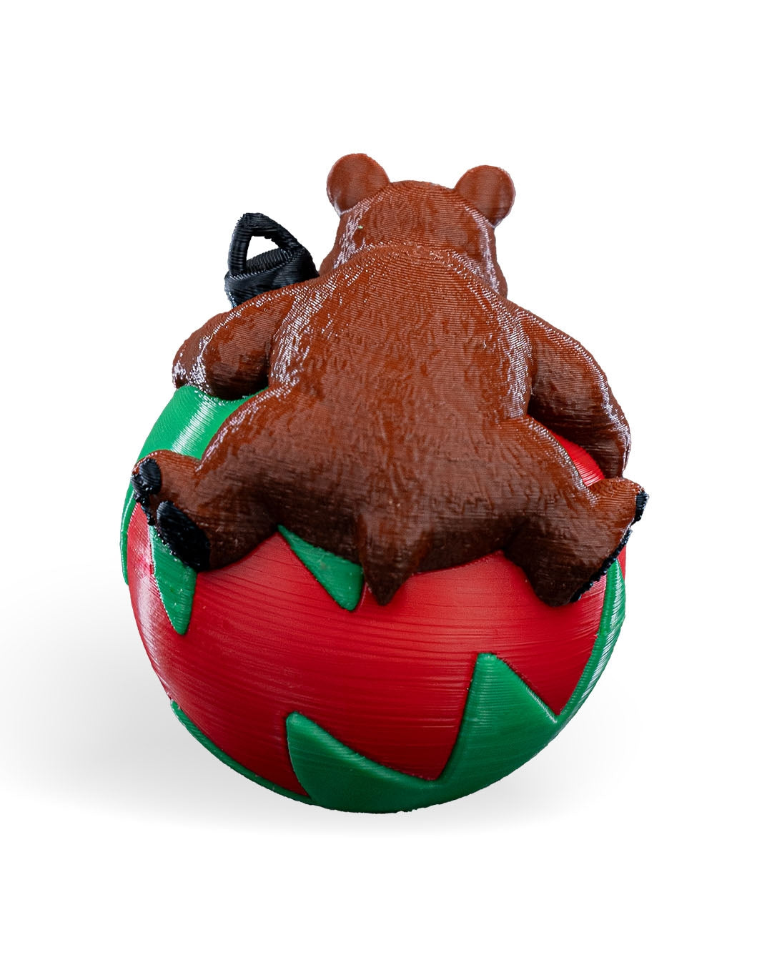 Back of the Sleeping Bear Christmas ornament showing the bear's back and legs over the red and green ball, on a white background