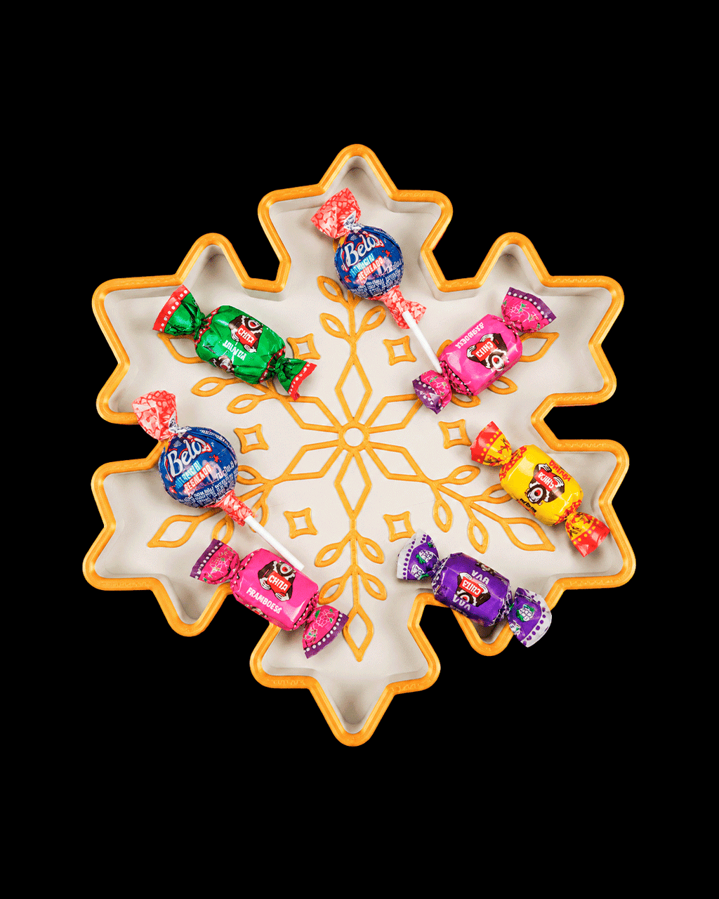 White and gold snowflake tray holding wrapped candies (candy not included), on a black background