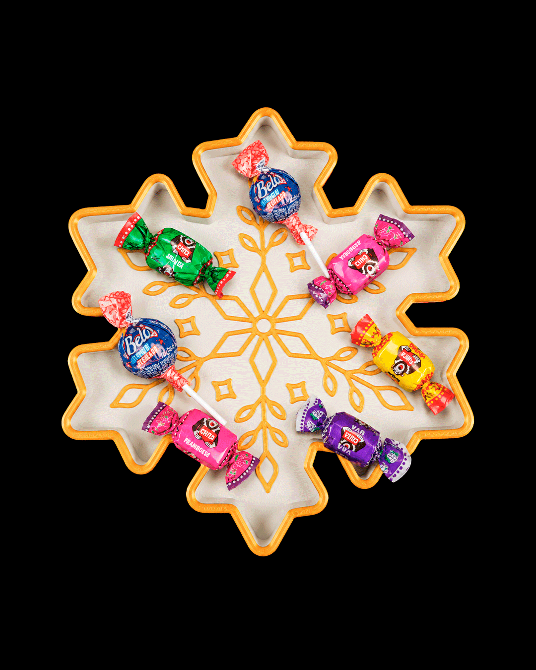 White and gold snowflake tray holding wrapped candies (candy not included), on a black background