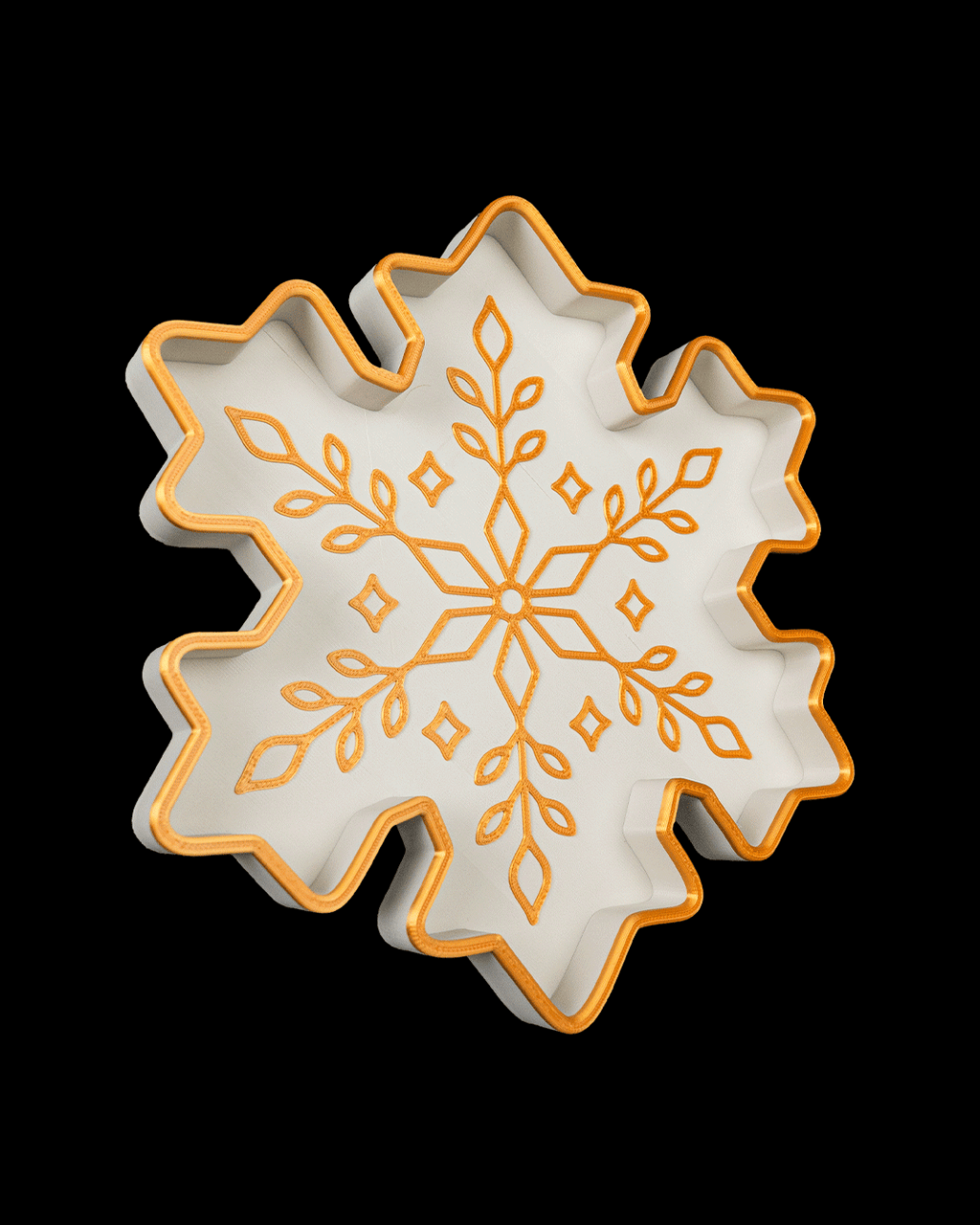 Angled view of the white and gold snowflake tray, on a black background