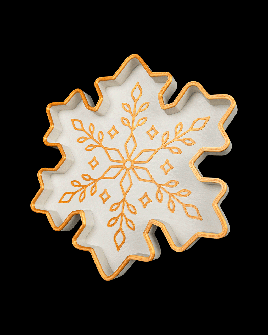 Another angled view of the white and gold snowflake tray, on a black background