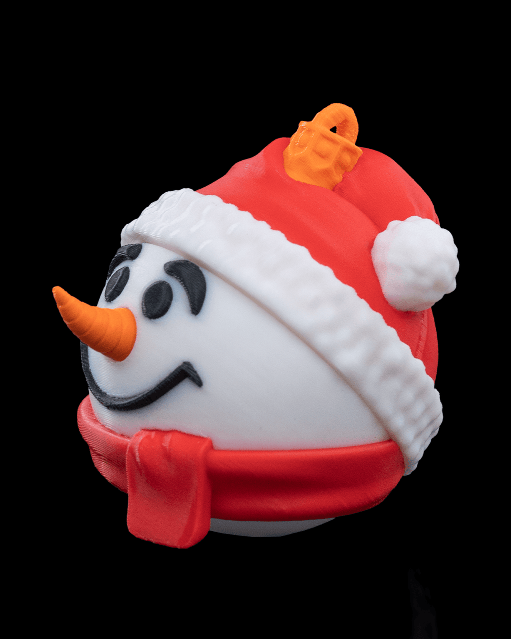 Snowman Christmas ornament turned to the left, showing the carrot nose, red hat pompom and red scarf, on a black background