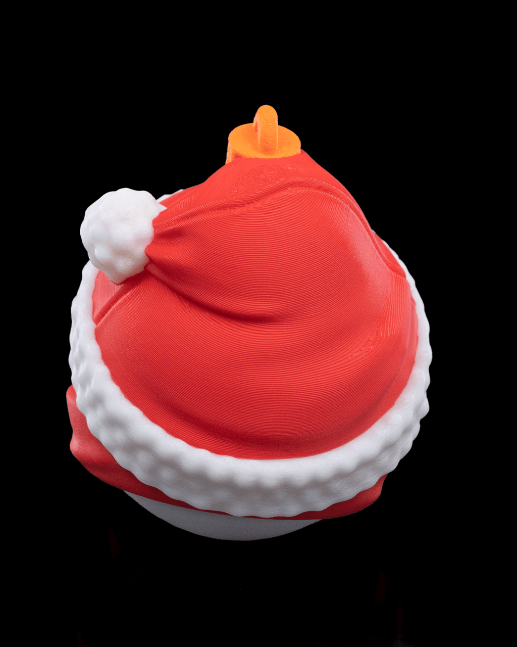 Back of the Snowman Christmas ornament showing the red hat, white trim and printed hanging loop, on a black background
