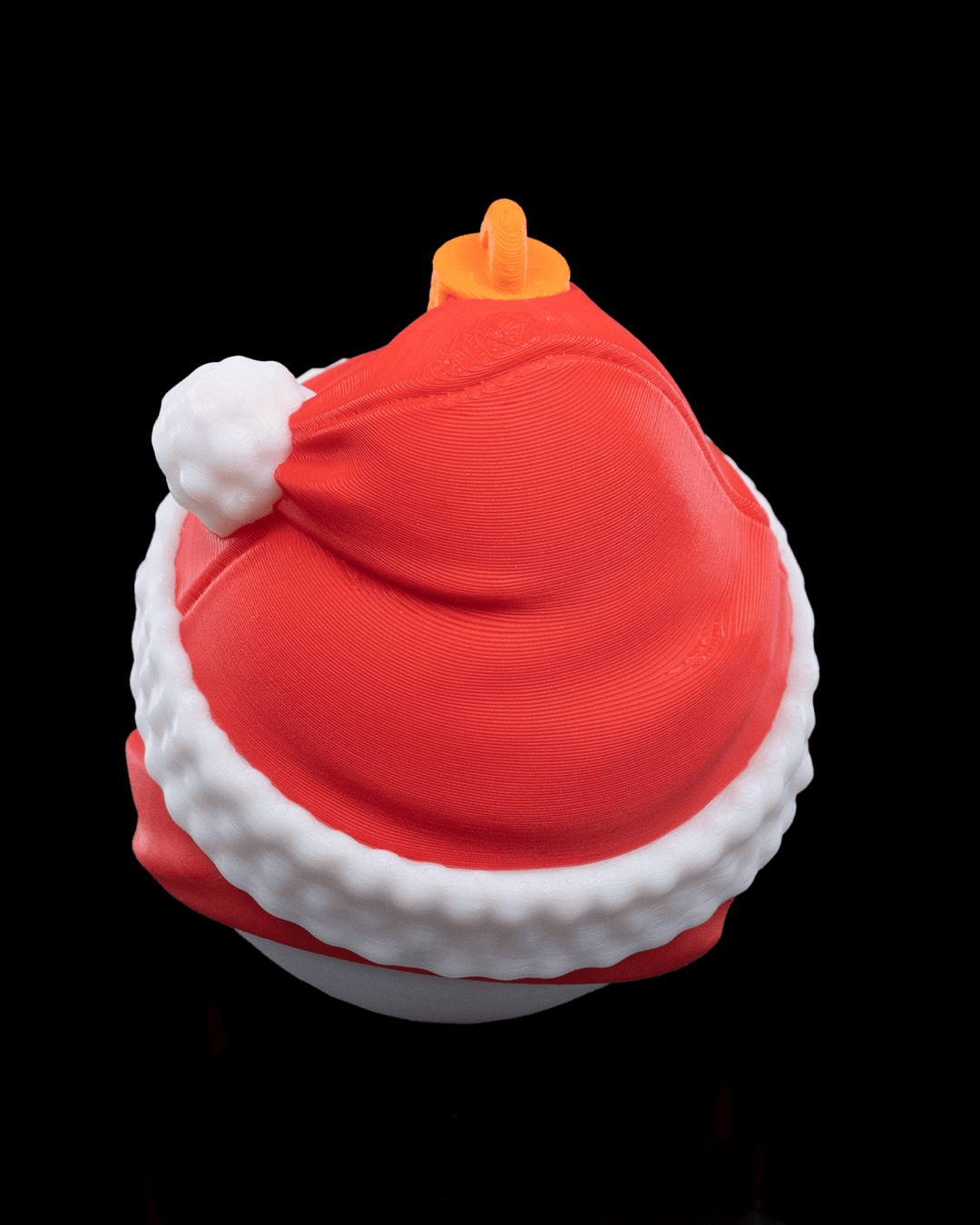 Back of the Snowman Christmas ornament showing the red hat, white trim and printed hanging loop, on a black background